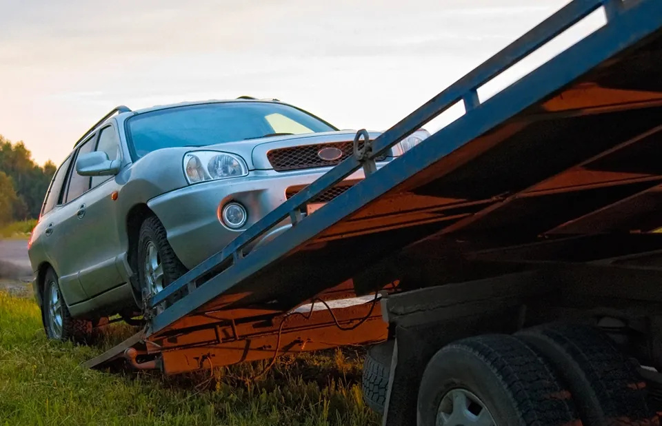 SUV being winched up a tilt-bed tow truck in Tampa, FL